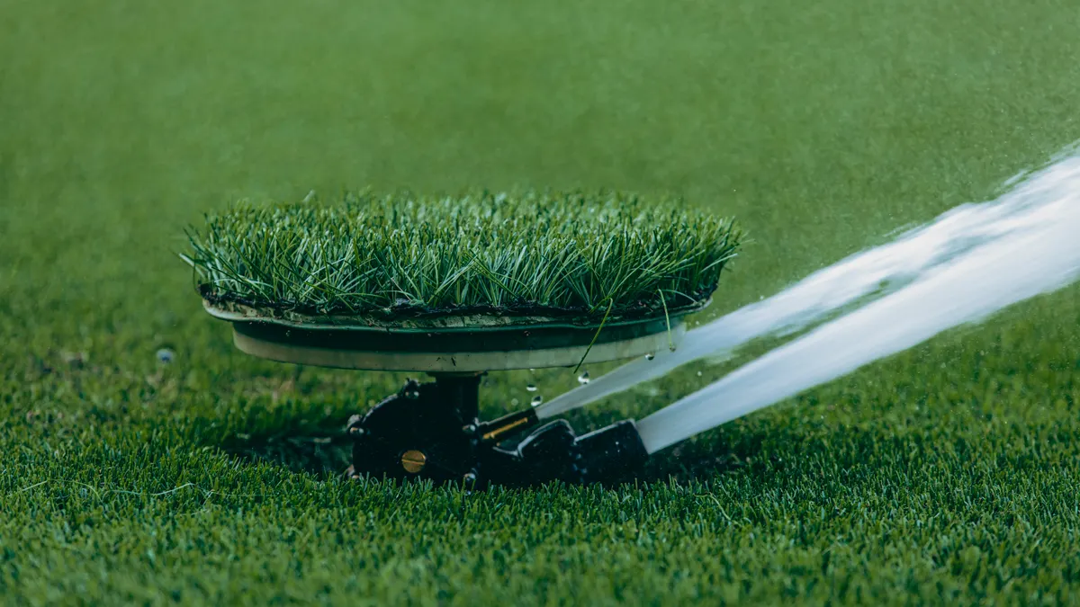 Pop-up lawn sprinkler with grass cover