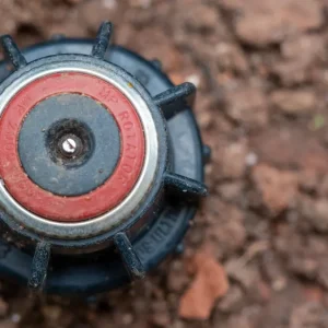 In-Ground Sprinkler Installation vs DIY: Which Costs More Up Front? — Top view of garden irrigation sprinkler on soil